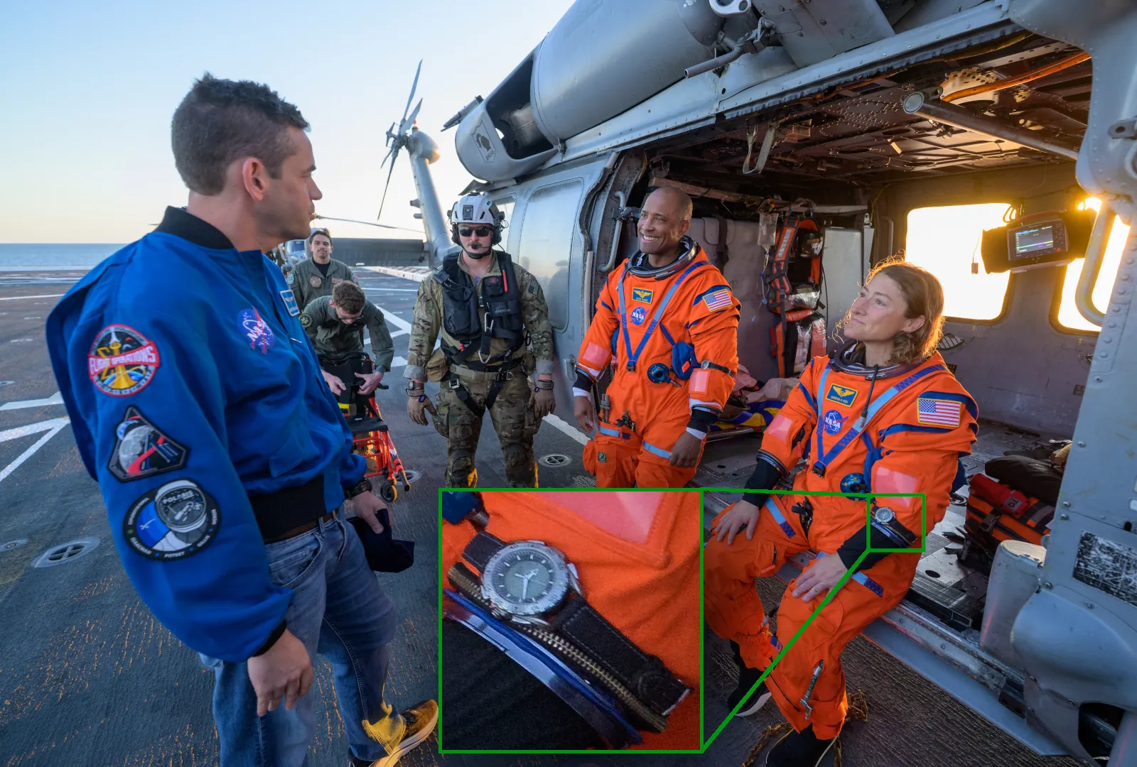 NASA astronauts Victor Glover and Christina Koch, seen with their Artemis II watch (Omega X-33 Gen 2), speaking with NASA Administrator Jared Isaacman on the deck of the USS John P. Murtha after the Orion spacecraft recovery.