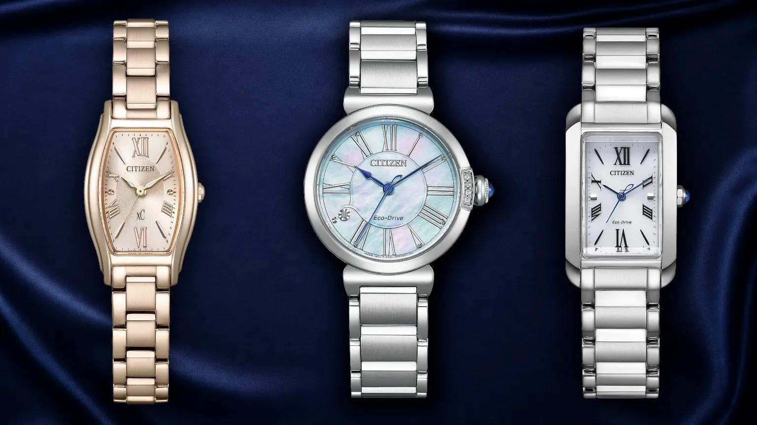 Three modern ladies' Citizen Eco-Drive watches—the Sakura Pink EW5546-56X, the diamond-accented EM1060-87Y, and the rectangular Bianca EW5620-55A—arranged on luxury fabric, showcasing mother-of-pearl dials and sapphire crystal.